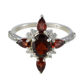 Carolina red gemstone fashion ring with central oval garnet and pear accents diamond halo on silver band